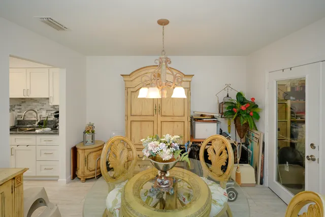 a dining room with furniture potted plants and wooden floor
