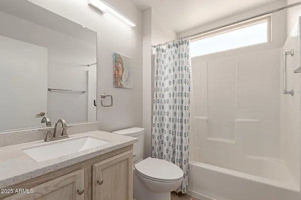 a bathroom with a granite countertop sink a toilet and shower