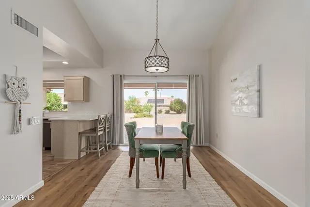 a dining room with furniture a chandelier and wooden floor