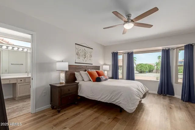 a bedroom with a large bed a large window with wooden floor