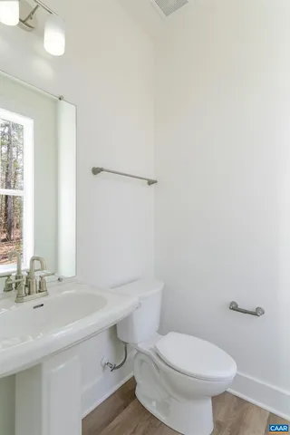 a bathroom with a sink a toilet and mirror
