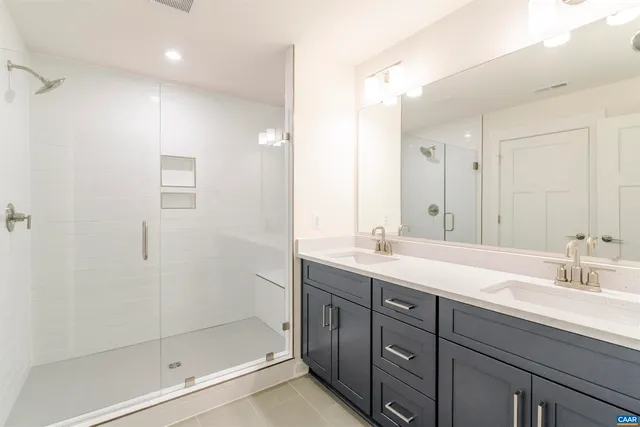 a bathroom with double sink and a mirror