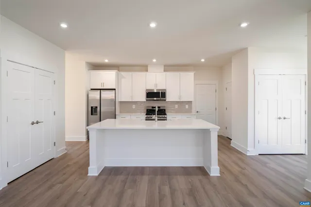 a view of kitchen with stainless steel appliances refrigerator sink and cabinets