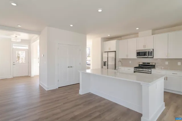 a kitchen with stainless steel appliances a refrigerator sink and microwave