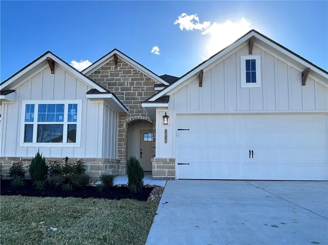 a front view of a house with a yard and potted plants