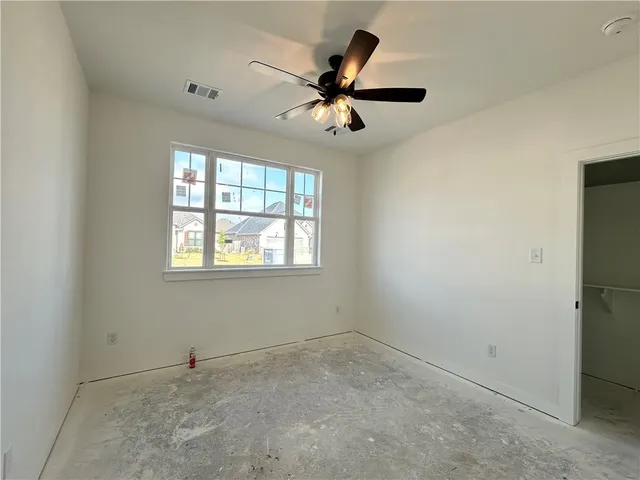an empty room with a window and a fan