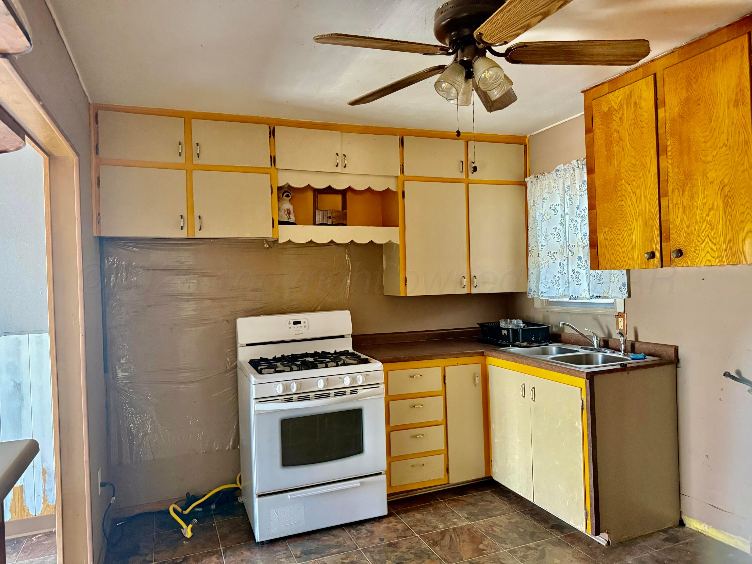 1518 South Williams Street Amarillo, TX 79102 - Photo 11 of 13 a kitchen with a stove a sink and cabinets