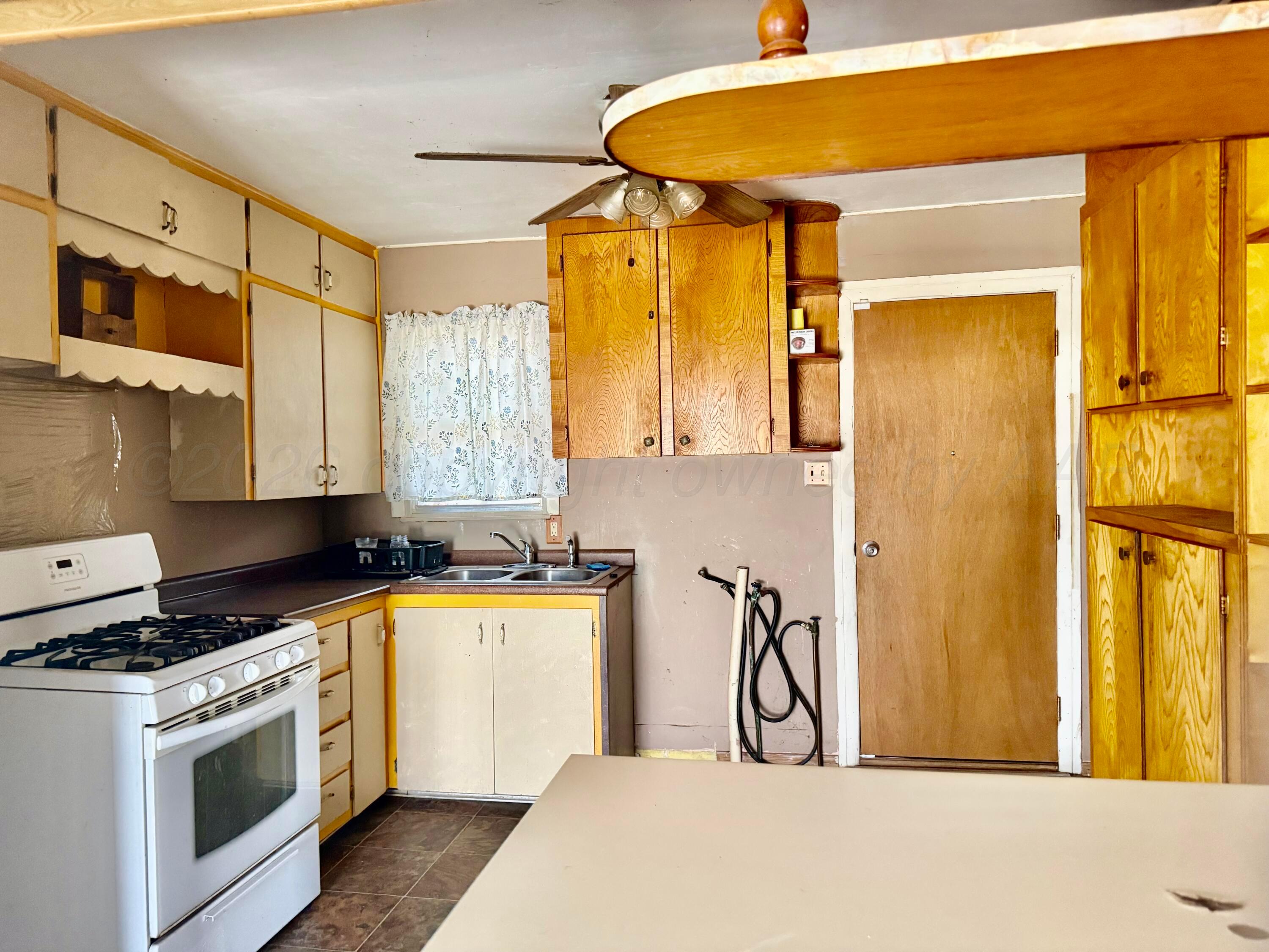1518 South Williams Street Amarillo, TX 79102 - Photo 7 of 13 a view of a kitchen with a sink and dishwasher a stove top oven with wooden floor