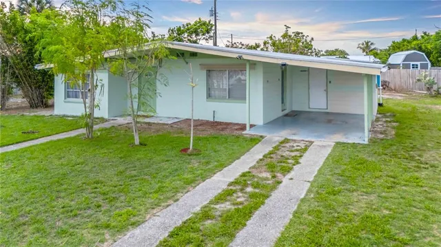 a view of a house with a yard and tree