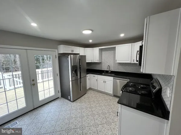 a kitchen with stainless steel appliances a refrigerator sink and cabinets