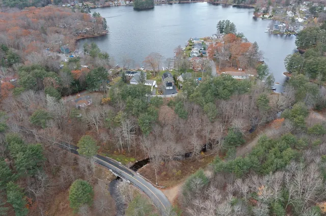 an aerial view of a house with a yard and lake view