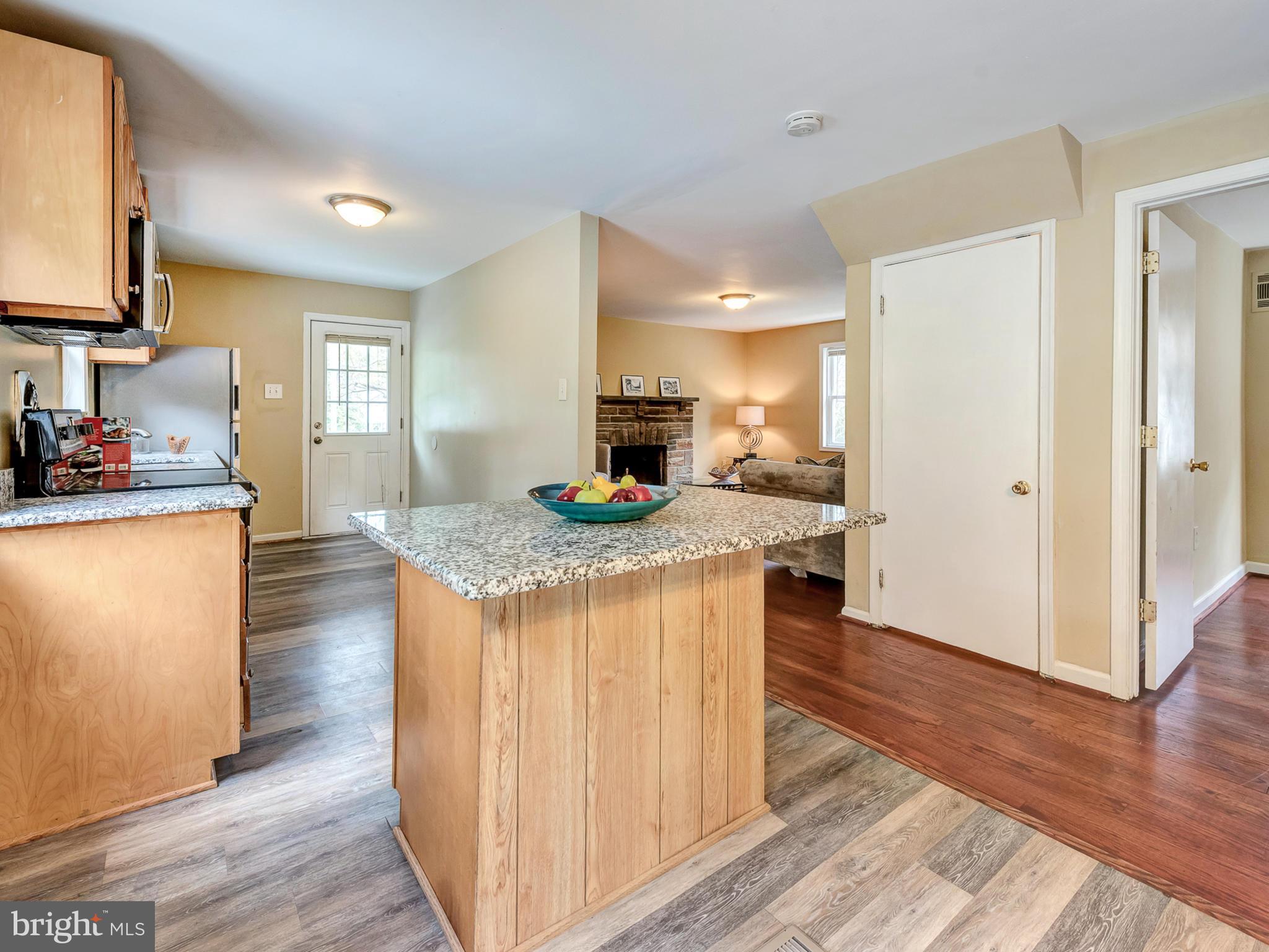 5812 Shookstown Road Frederick, MD 21702 - Photo 11 of 31 a kitchen with kitchen island granite countertop wooden floors and a sink