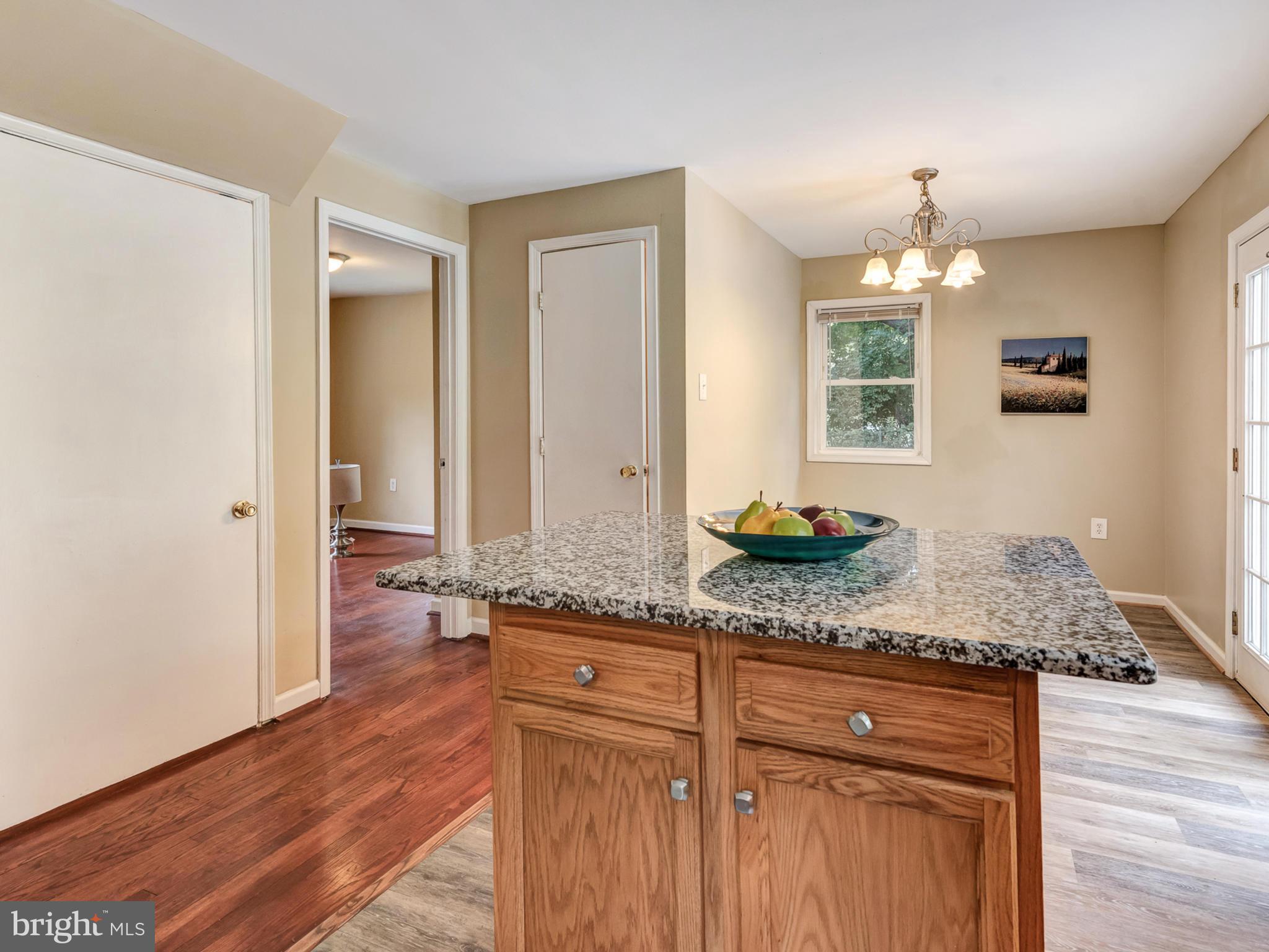 5812 Shookstown Road Frederick, MD 21702 - Photo 12 of 31 a hallway with granite countertop white cabinets and a wooden floor