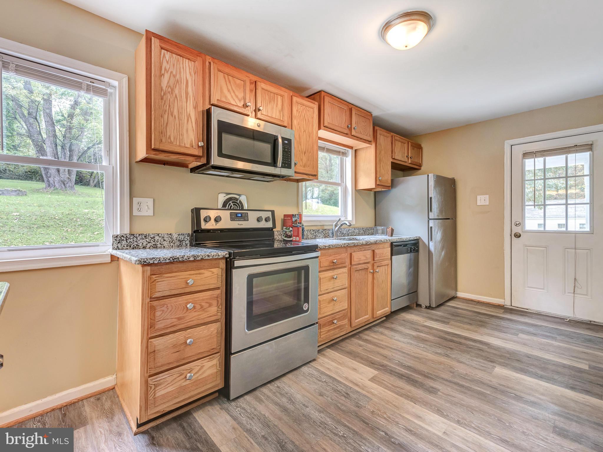 5812 Shookstown Road Frederick, MD 21702 - Photo 7 of 31 a kitchen with stainless steel appliances granite countertop a stove a sink and a refrigerator