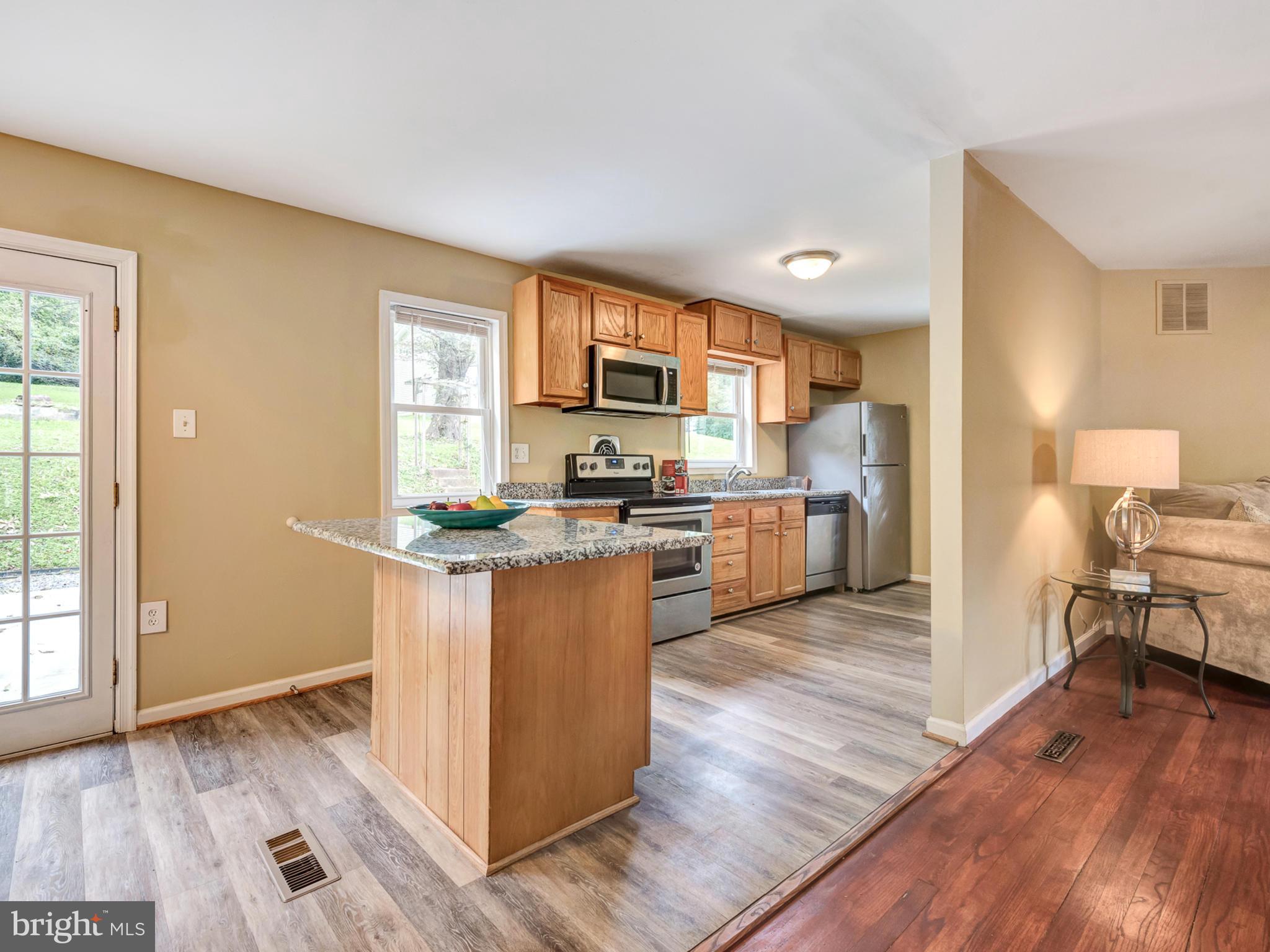 5812 Shookstown Road Frederick, MD 21702 - Photo 8 of 31 a kitchen with granite countertop wooden floors and stainless steel appliances