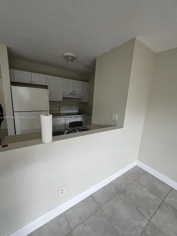 a view of kitchen with refrigerator and microwave