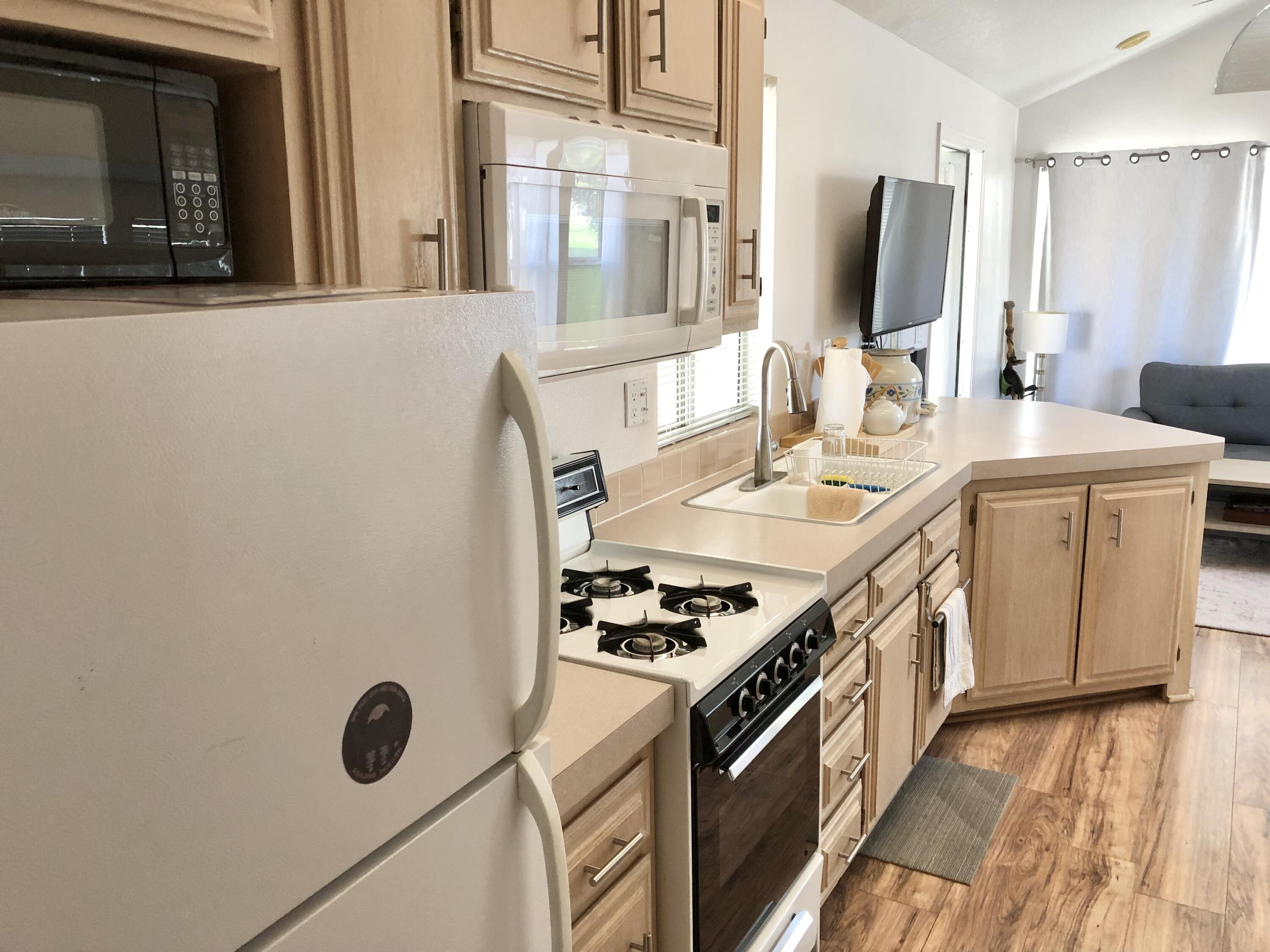 74711 Dillon Road Desert Hot Springs, CA 92241 - Photo 11 of 37 a kitchen with a sink stove and microwave