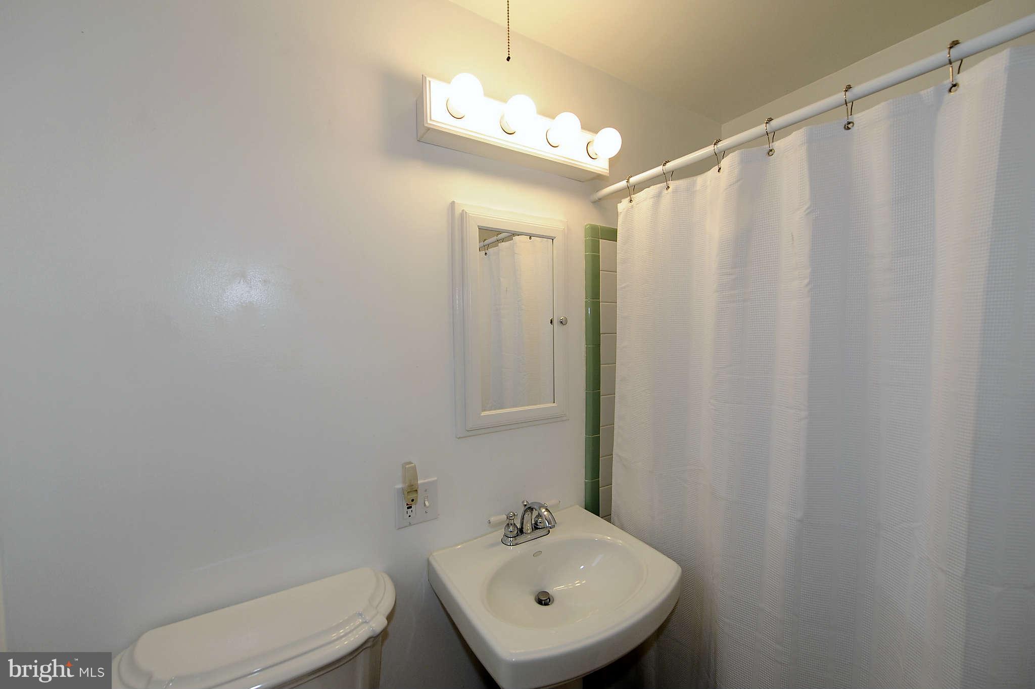 5411 Inverchapel Road Springfield, VA 22151 - Photo 18 of 22 a bathroom with a sink a toilet and shower curtain