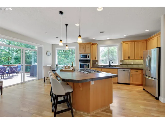 a kitchen with kitchen island a counter top space a sink appliances and cabinets