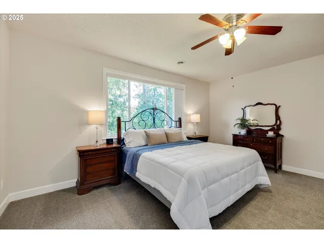 a bedroom with a bed and a ceiling fan