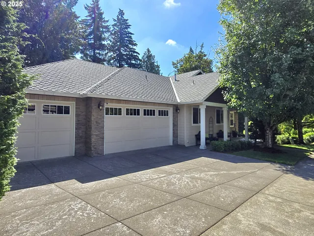 a front view of a house with a garden and trees