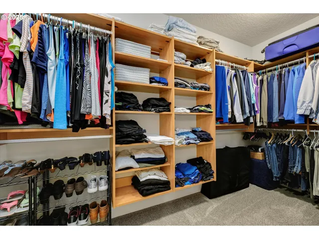 a view of walk in closet with clothes and shoes