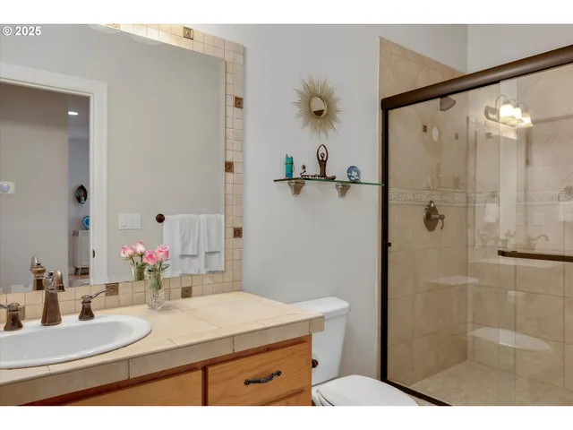 a bathroom with a sink vanity granite shower and a mirror