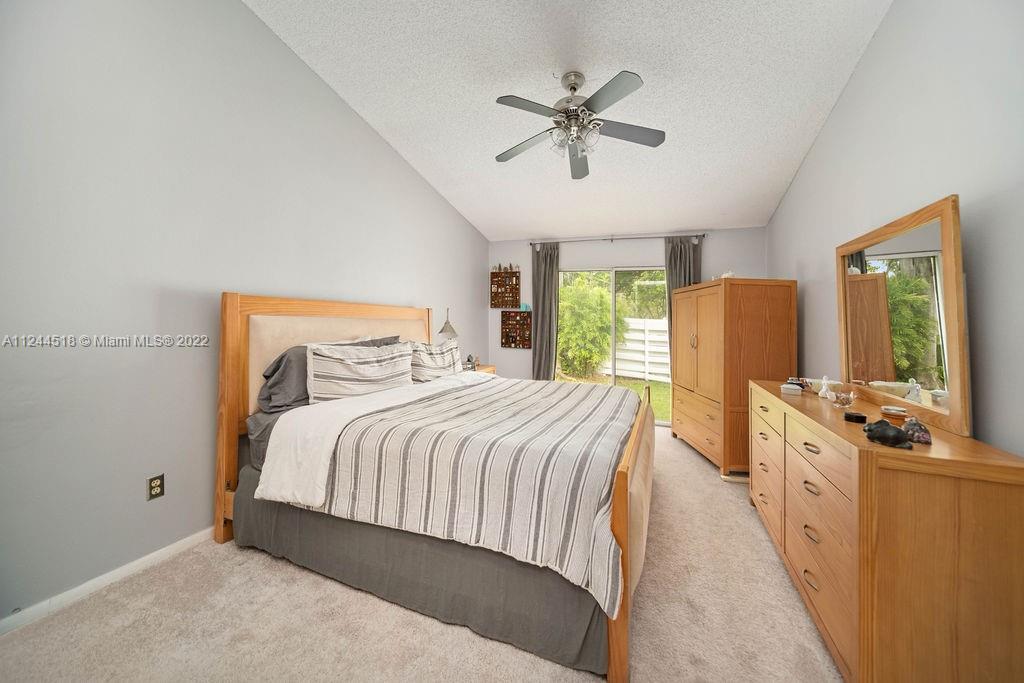 14914 Southwest 142nd Place Miami, FL 33186 - Photo 16 of 27 a bedroom with a large bed and a chandelier