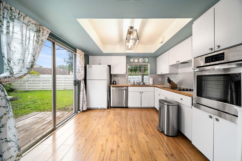 14914 Southwest 142nd Place Miami, FL 33186 - Photo 21 of 27 a kitchen with a refrigerator a sink and cabinets