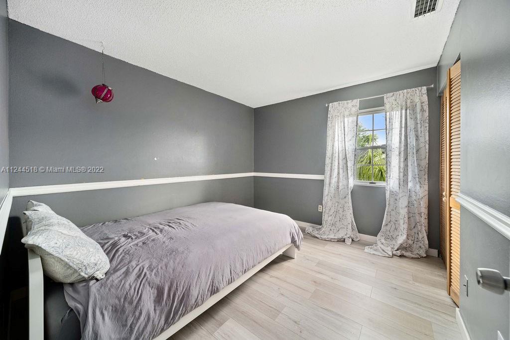 14914 Southwest 142nd Place Miami, FL 33186 - Photo 5 of 27 a bedroom with a bed and a window
