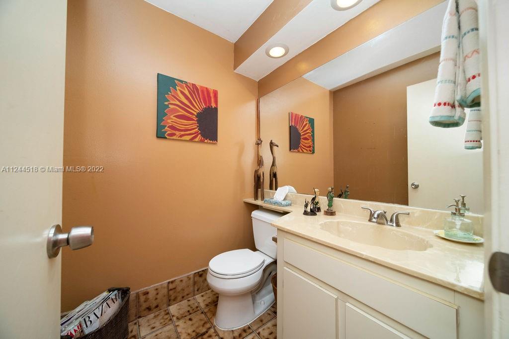 14914 Southwest 142nd Place Miami, FL 33186 - Photo 8 of 27 a bathroom with a toilet sink vanity and mirror