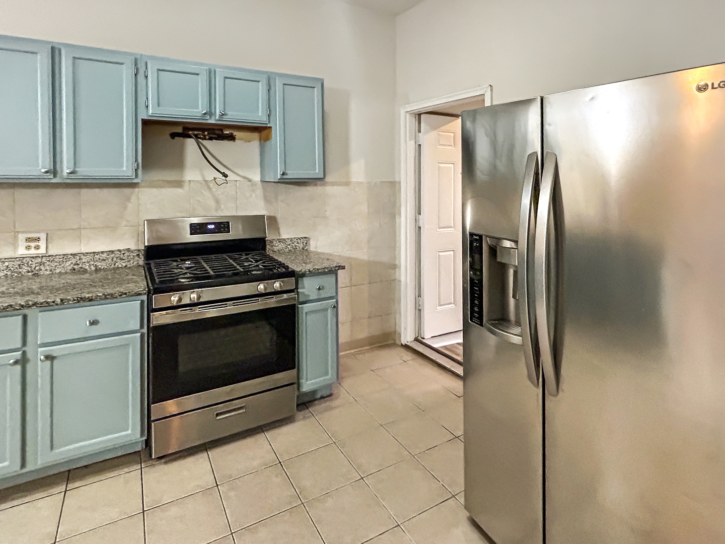 2953 West Warren Boulevard, Unit 2 Chicago, IL 60612 - Photo 11 of 31 a kitchen with stainless steel appliances granite countertop a stove and a refrigerator