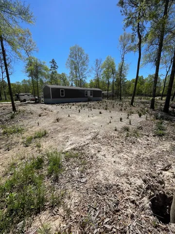 a view of a yard with wooden fence