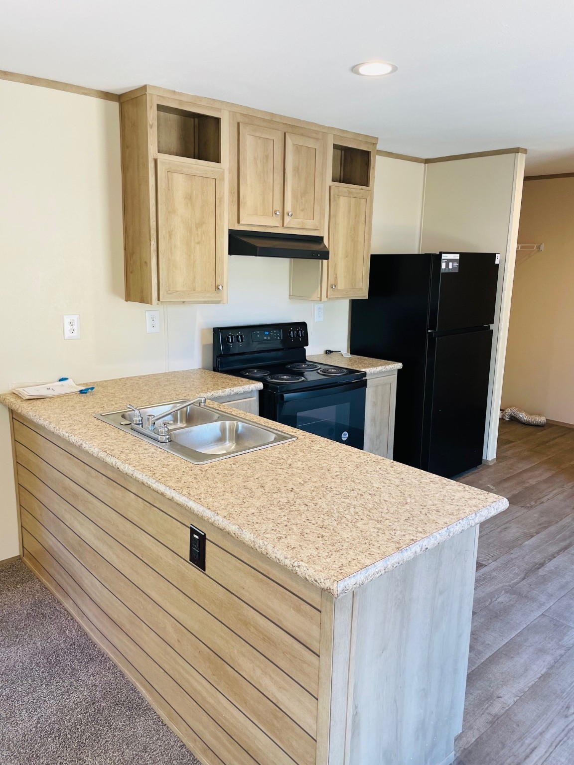 30 Hellon Lane Shepherd, TX 77371 - Photo 6 of 14 a kitchen with granite countertop a refrigerator a stove and wooden cabinets