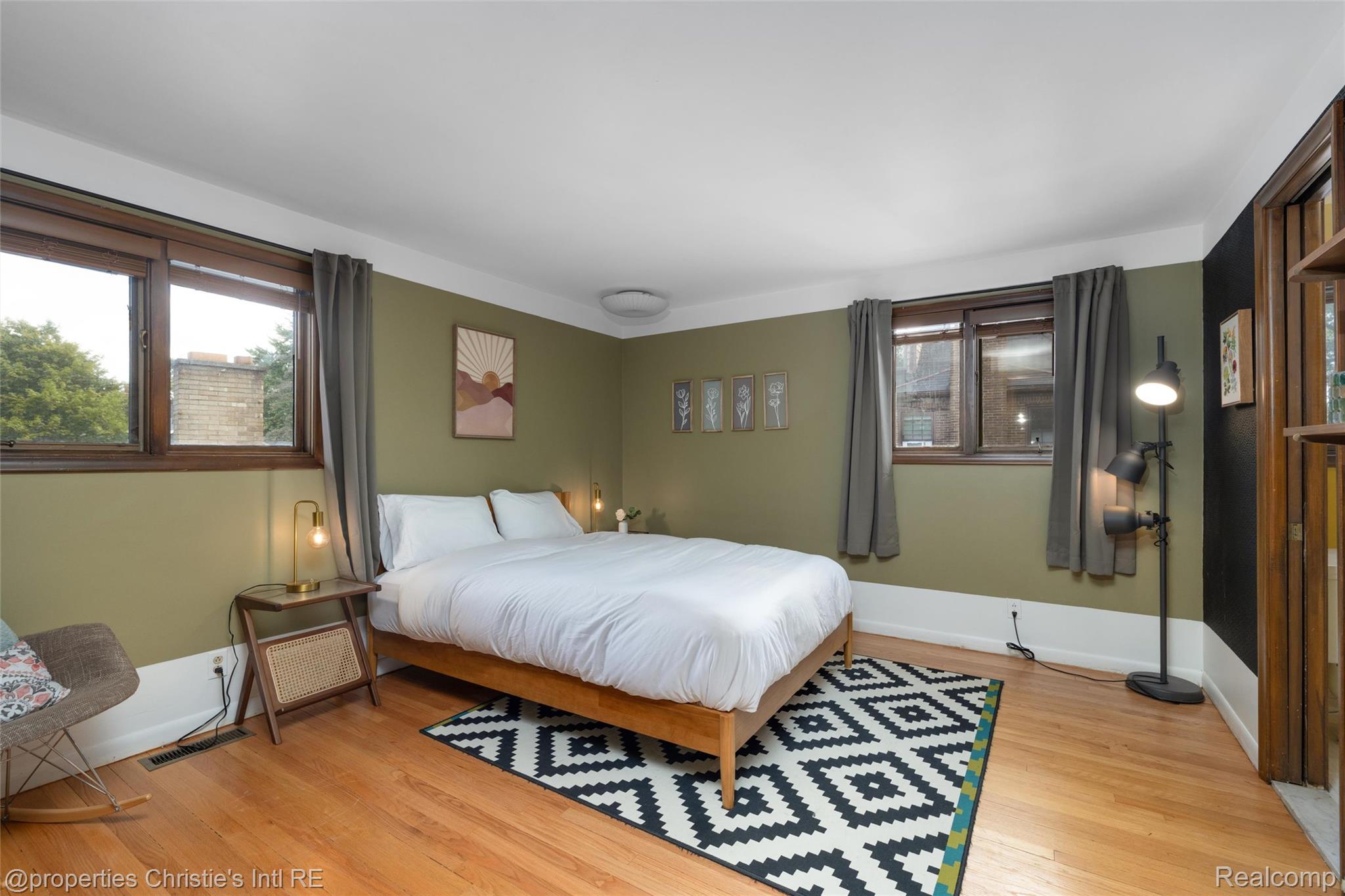 2771 West Seven Mile Road Detroit, MI 48221 - Photo 46 of 57 Spacious room featuring hardwood flooring, multiple windows with dark wood trim, and a built-in wooden shelving unit