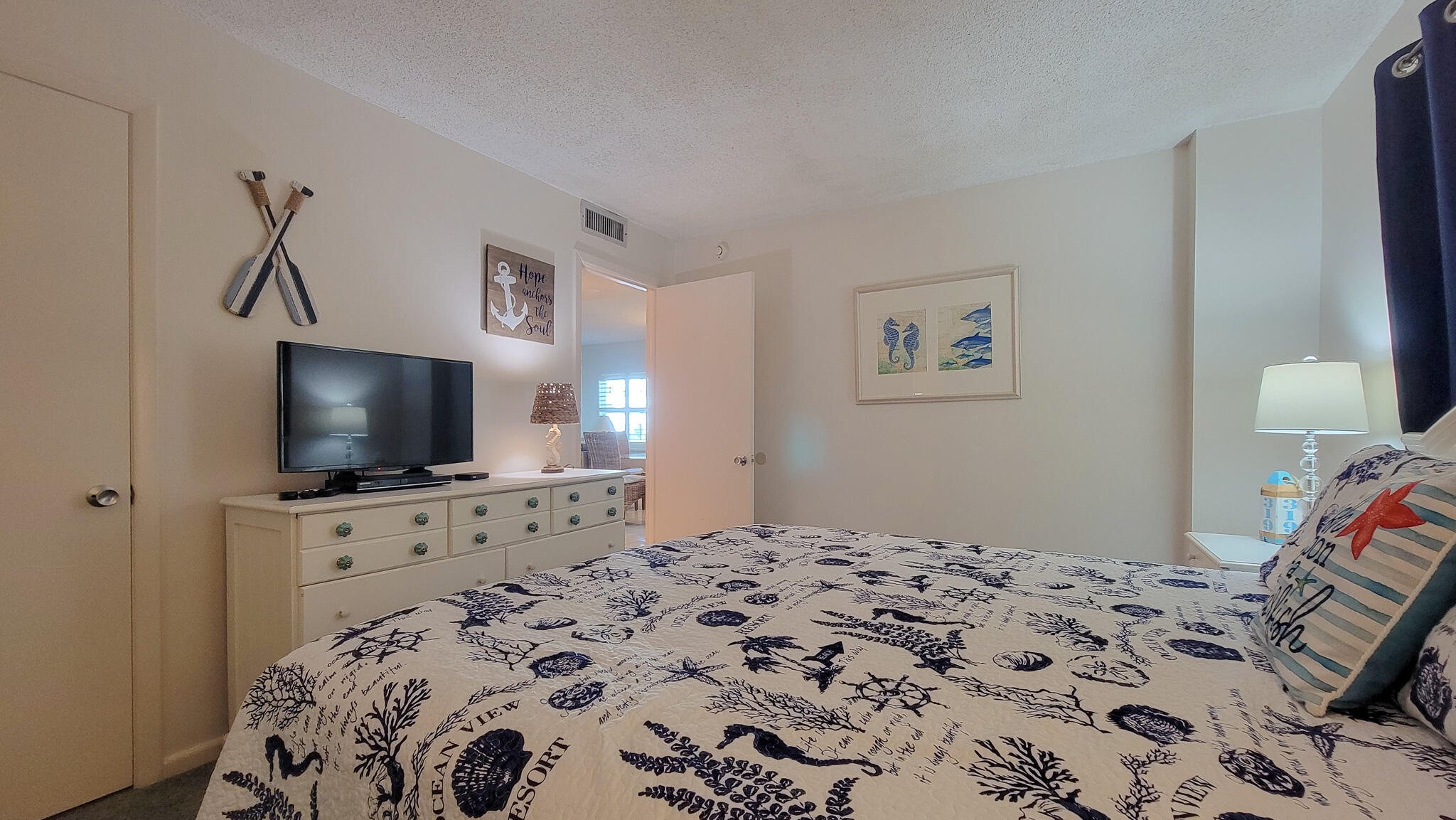 909 Santa Rosa Boulevard, Unit 319 Fort Walton Beach, FL 32548 - Photo 18 of 39 a bedroom with a bed and a flat screen tv