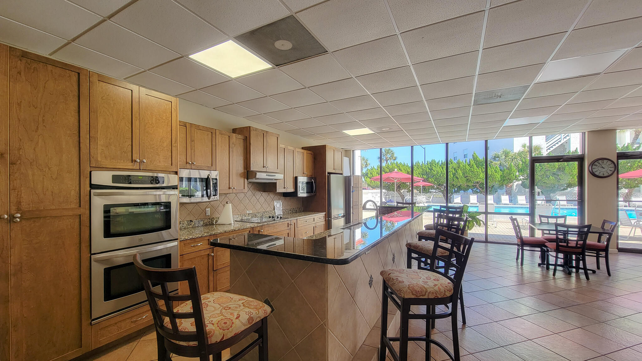 909 Santa Rosa Boulevard, Unit 319 Fort Walton Beach, FL 32548 - Photo 35 of 39 a kitchen with stainless steel appliances wooden cabinets dining table and chairs