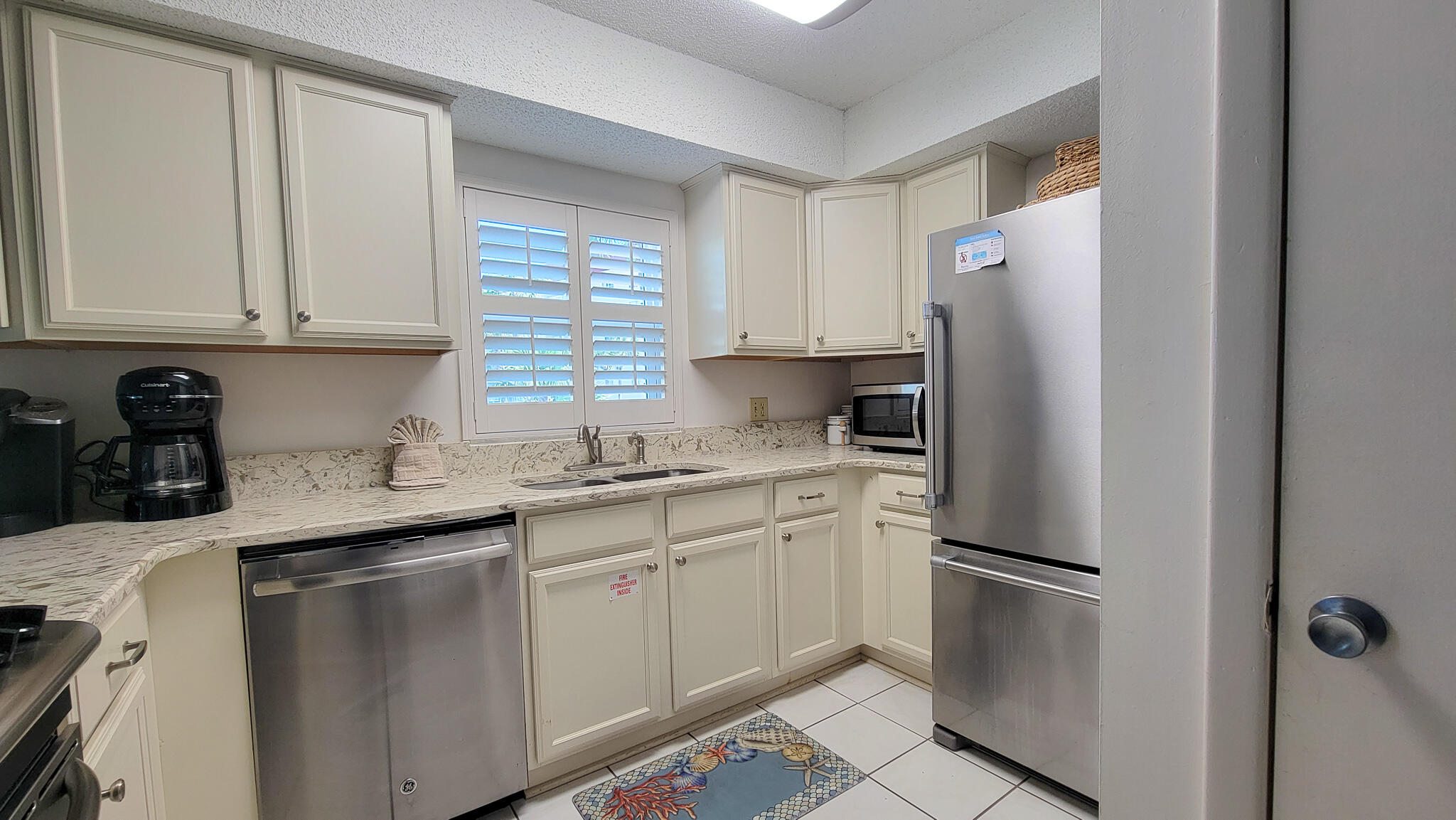 909 Santa Rosa Boulevard, Unit 319 Fort Walton Beach, FL 32548 - Photo 4 of 39 a kitchen with a sink a refrigerator and cabinets