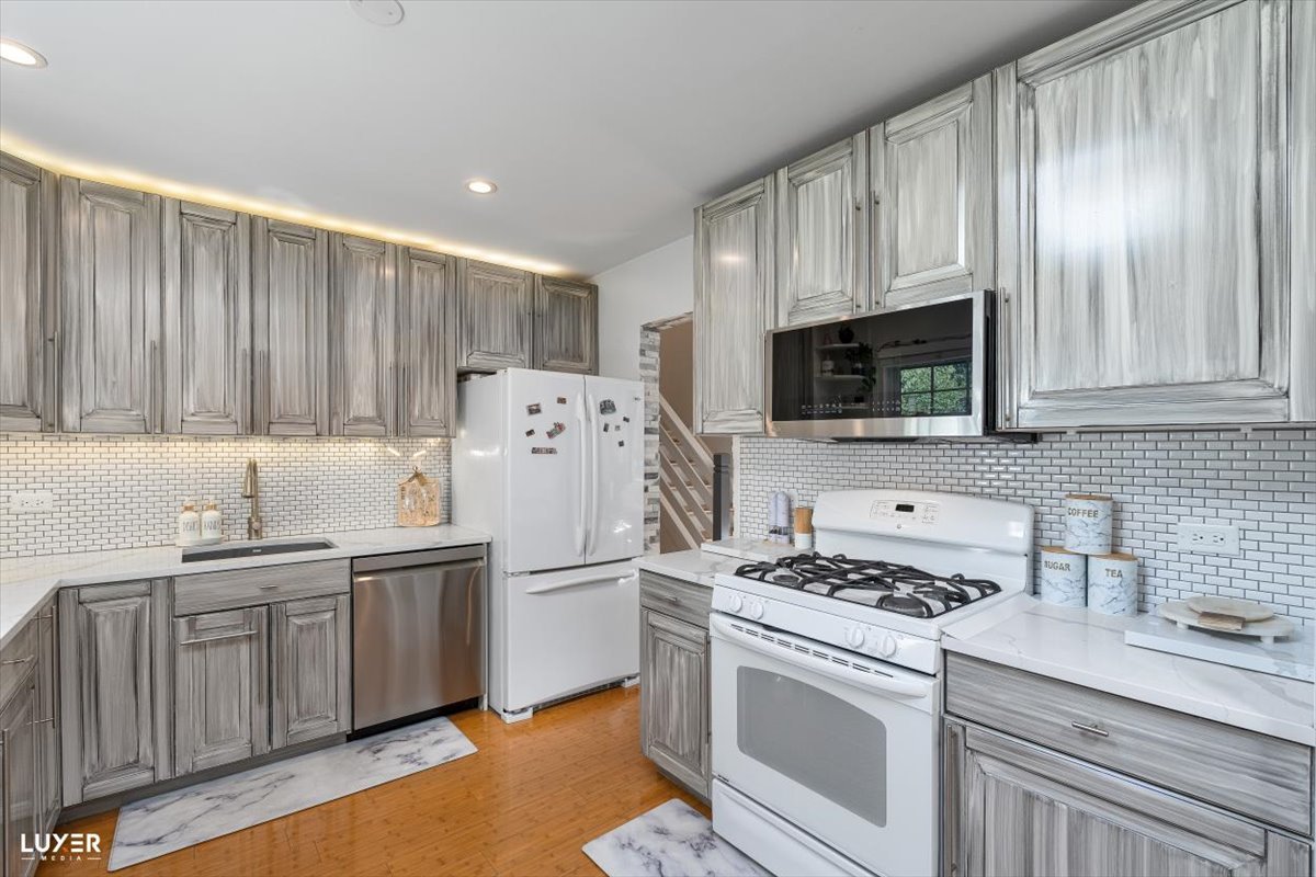 6908 Orchard Lane Hanover Park, IL 60133 - Photo 12 of 28 a kitchen with a sink cabinets and stainless steel appliances