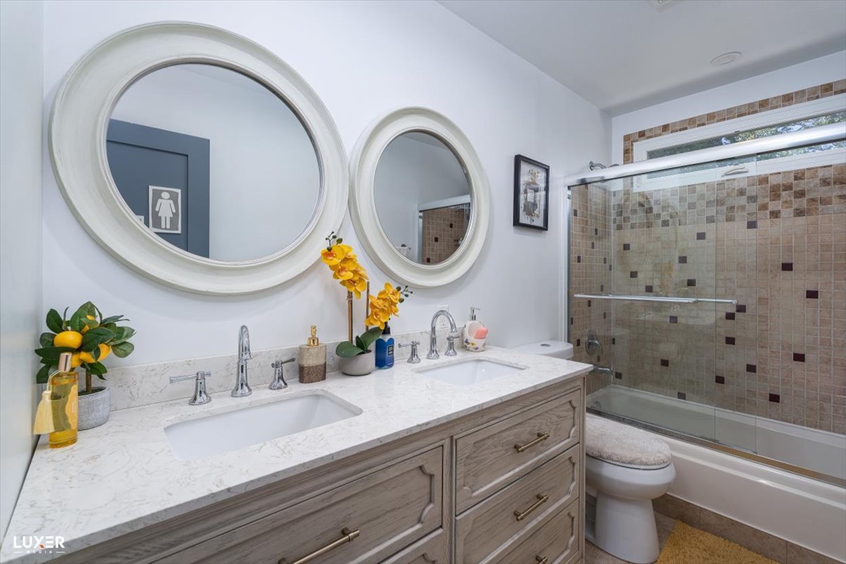 6908 Orchard Lane Hanover Park, IL 60133 - Photo 19 of 28 a bathroom with a sink a mirror a toilet and a shower curtain
