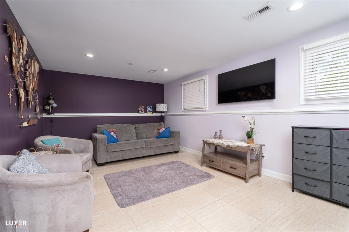 6908 Orchard Lane Hanover Park, IL 60133 - Photo 20 of 28 a living room with furniture and a flat screen tv