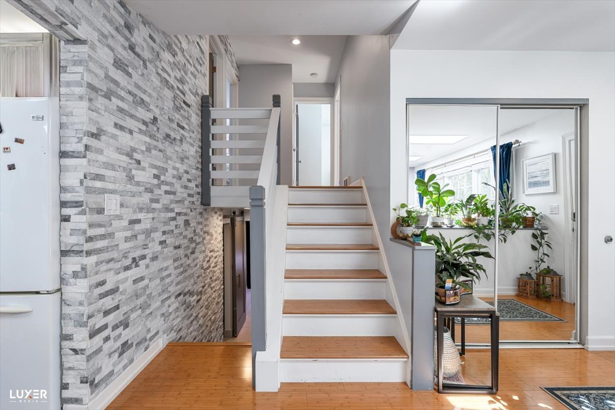 6908 Orchard Lane Hanover Park, IL 60133 - Photo 6 of 28 a view of staircase with wooden floor and a potted plant