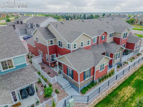 an aerial view of multiple houses with a big yard