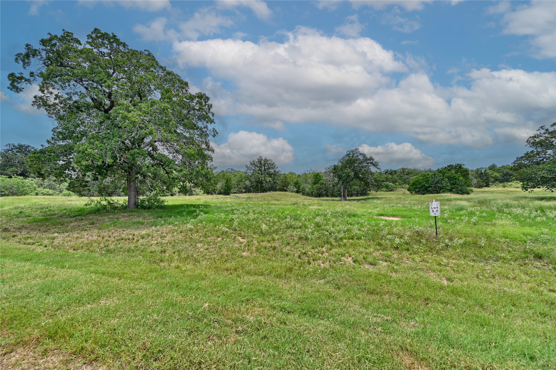 a view of a green field with wooden fence