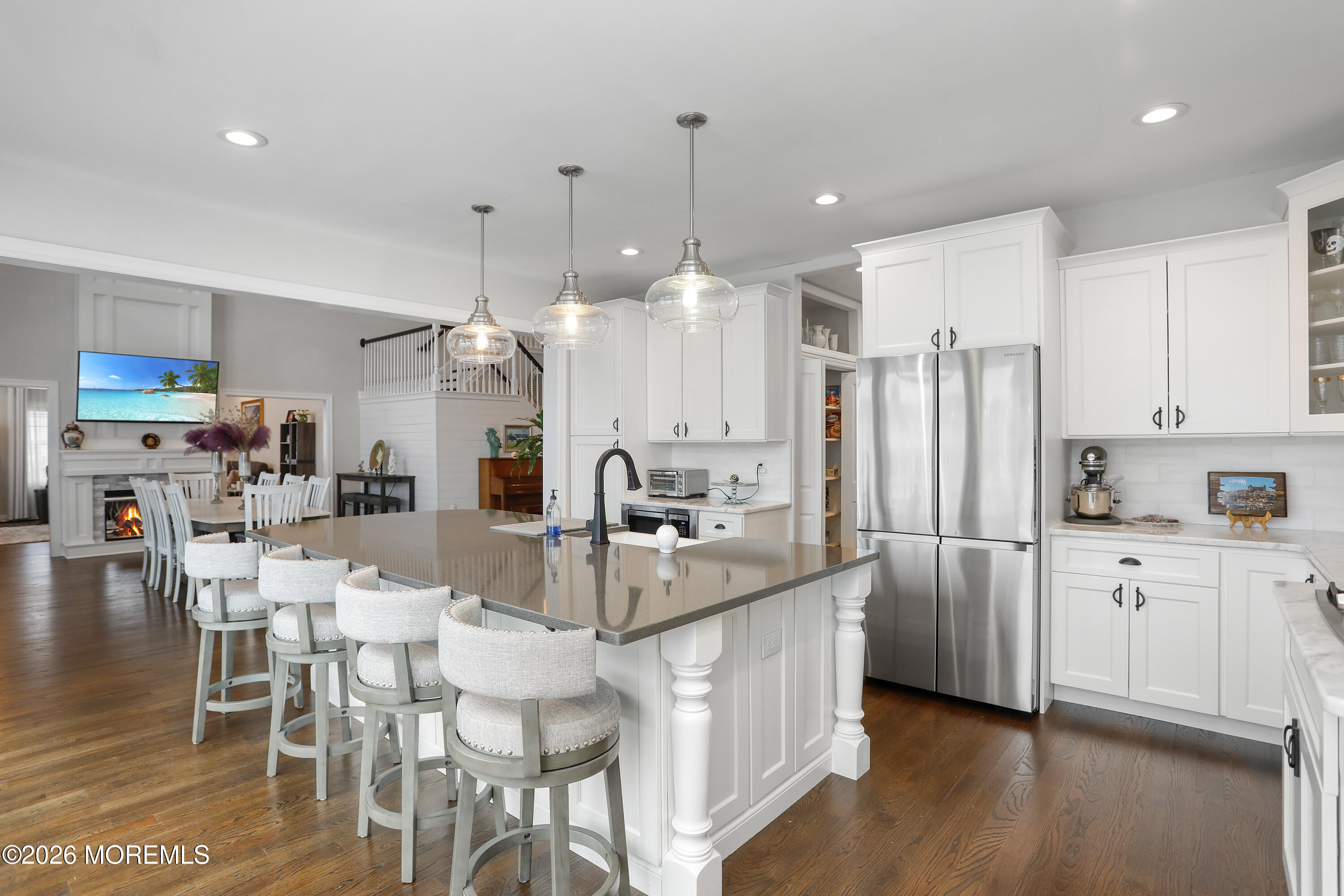 50 Neptune Road Toms River, NJ 08753 - Photo 15 of 73 a kitchen with stainless steel appliances kitchen island granite countertop a refrigerator a stove a sink dishwasher and a dining table with wooden floor