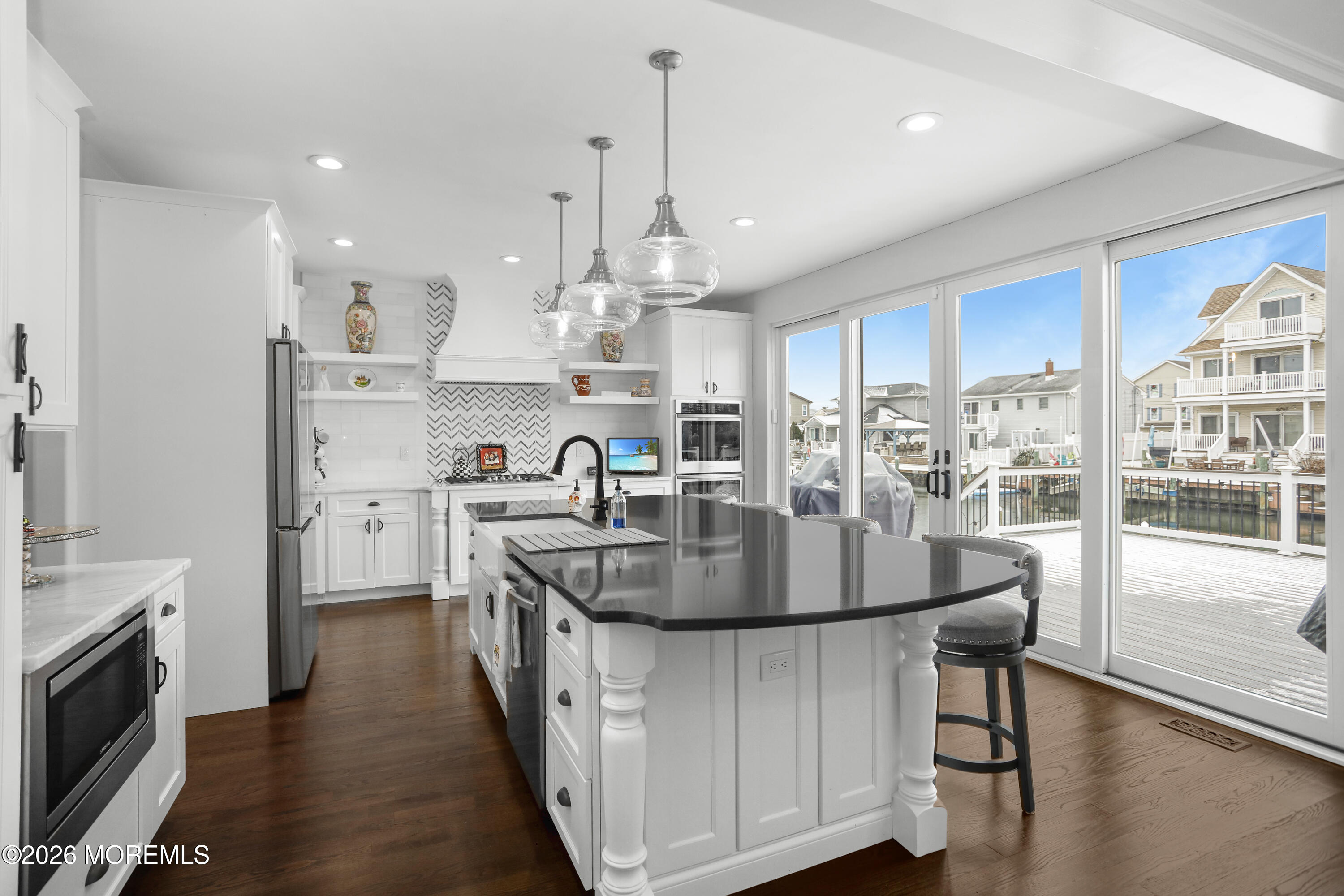 50 Neptune Road Toms River, NJ 08753 - Photo 18 of 73 a kitchen with stainless steel appliances granite countertop a stove a sink a refrigerator and a dining table with wooden floor
