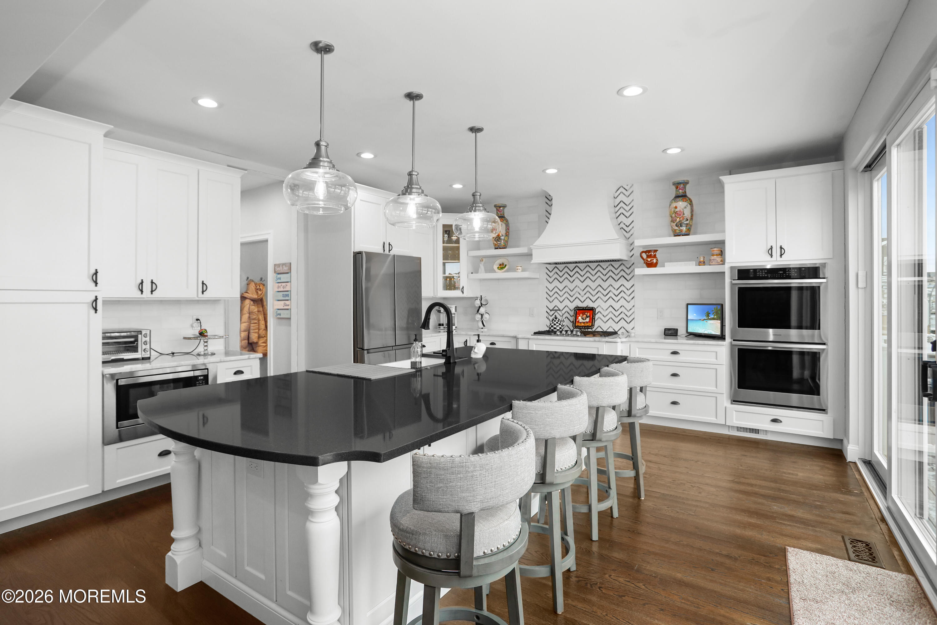 50 Neptune Road Toms River, NJ 08753 - Photo 19 of 73 a kitchen with stainless steel appliances granite countertop a sink a stove a refrigerator and a dining table with wooden floor