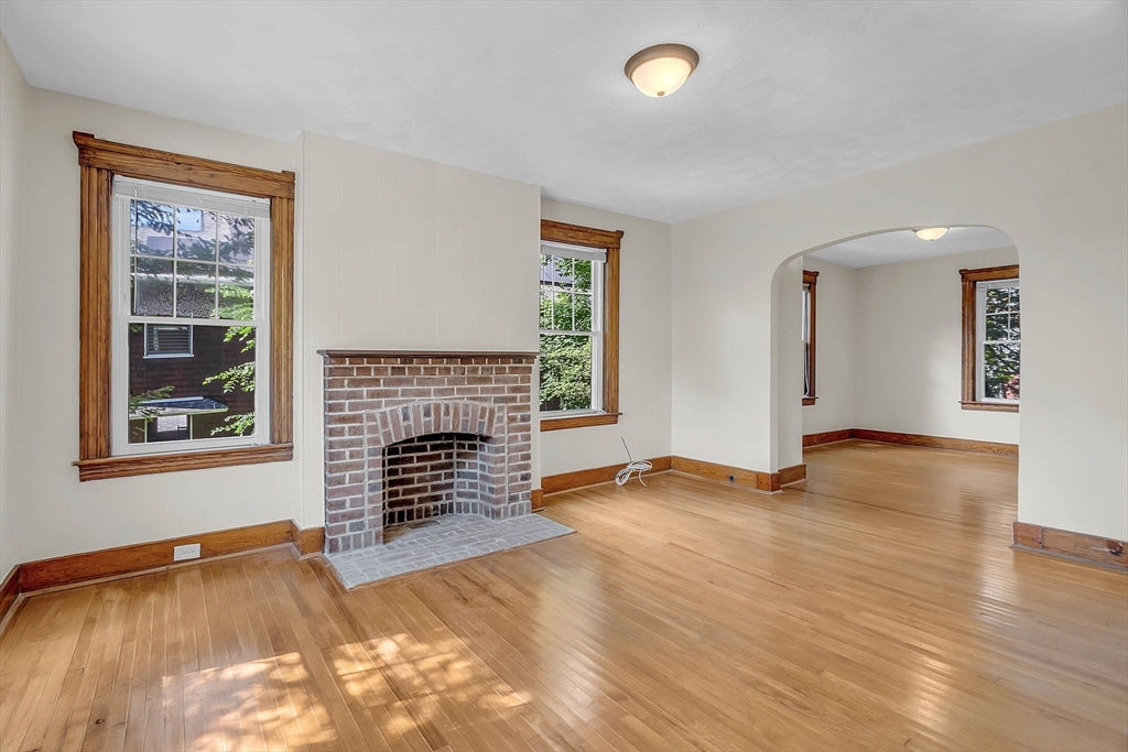 5 Wakefield Street Worcester, MA 01605 - Photo 13 of 42 an empty room with windows fireplace and wooden floor
