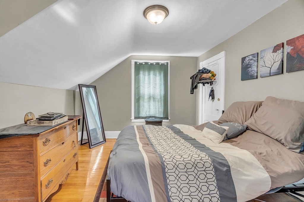 5 Wakefield Street Worcester, MA 01605 - Photo 32 of 42 a bedroom with a bed and dresser with mirror