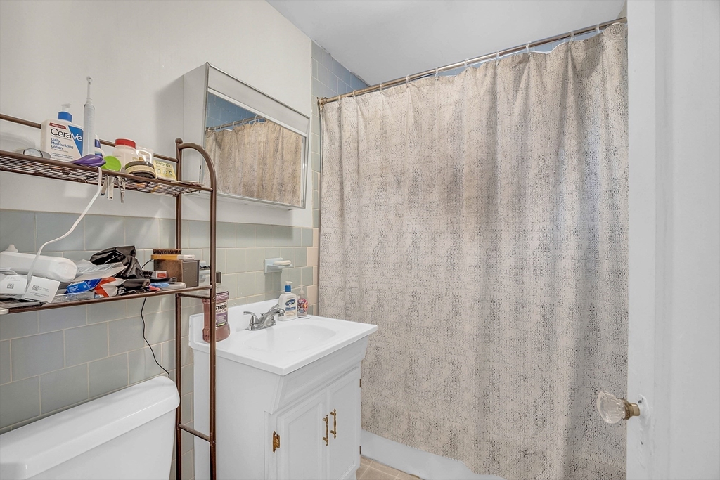 5 Wakefield Street Worcester, MA 01605 - Photo 38 of 42 a bathroom with a sink a vanity and a shower curtain